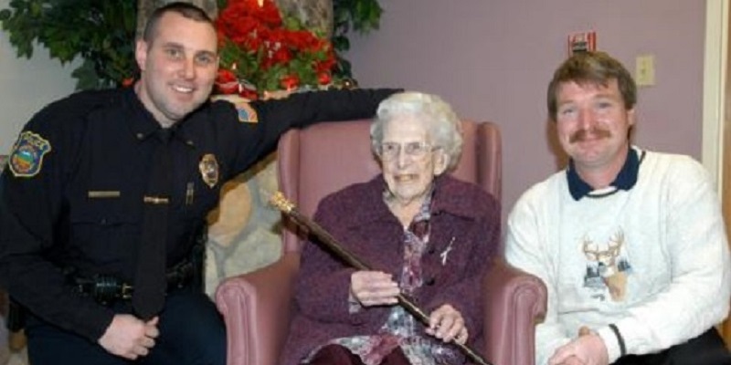 Police Officer Kneeling next To Elderly Woman and Care Taker
