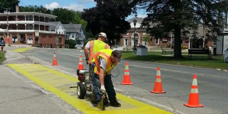 Two Construction Workers Painting Sidewalk
